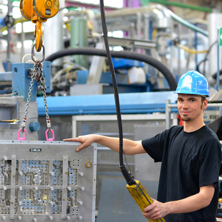 worker operates a crane in an industrial plant - interior in a factory hallの写真素材
