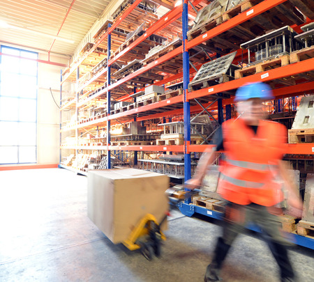 workers in the warehouse of a forklift truck - speed in logistics - blurred movementの写真素材