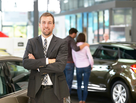 successful businessman in a car dealership - sale of vehicles to customersの写真素材