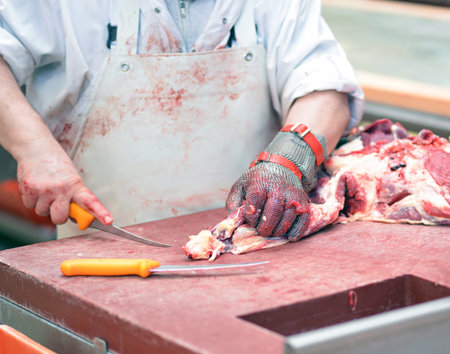 butcher works in a slaughterhouse and cuts freshly slaughtered meat (beef and pork) for sale and...