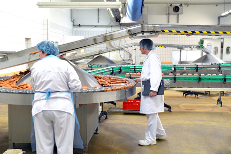 quality control in a meat processing plant - production of sausages in a factoryの写真素材