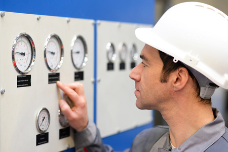 Industrial workers read the instruments of a machineの写真素材