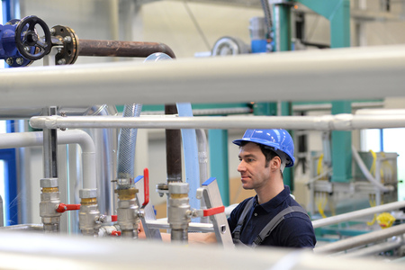 industrial workers inspect the technology of a plant for function - assembler in working clothesの写真素材