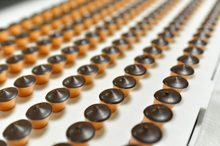Production of pralines in a factory for the food industry - automatic conveyor belts with chocolateの写真素材