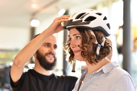 Bicycle shop consulting - customer tests a bicycle helmet for road safetyの写真素材