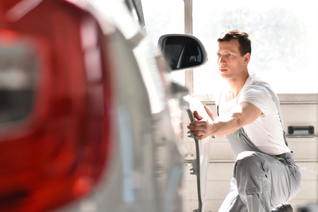car mechanic inspects vehicle in a workshopの写真素材