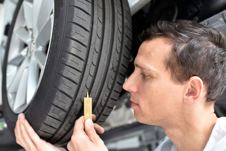 mechanic controls tread depth of a car tireの写真素材