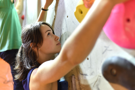 syoung, sporty pretty woman climbing up a wall in a bouldering hall - indoor sportsの写真素材