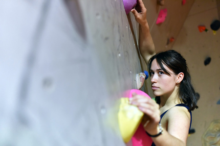 syoung, sporty pretty woman climbing up a wall in a bouldering hall - indoor sportsの写真素材