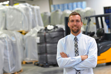 portrait of a manager in a logistics company - in the background a warehouse with chemicals and goods of a chemical factoryの写真素材