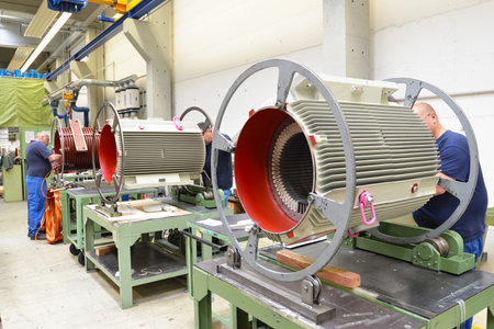 Workers in a factory assemble electric motors