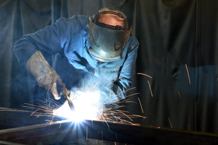 welder works in metal construction - construction and processing of steel components 