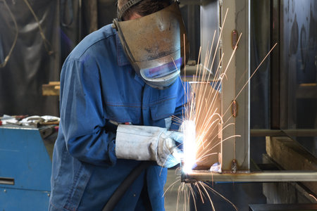 welder works in metal construction - construction and processing of steel components 