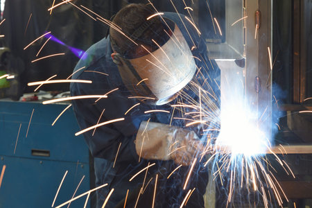 welder works in metal construction - construction and processing of steel components 