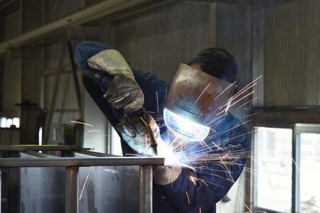 welder works in metal construction - construction and processing of steel components 