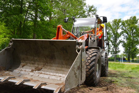 Construction worker drives a small wheel loader on the construction site 