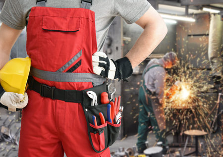 cheerful industrial worker in a factory in work clothes to repair machines and equipment