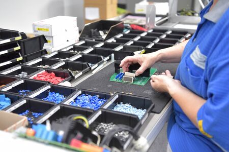 friendly woman working in a microelectronics manufacturing factory - component assembly and soldering の写真素材