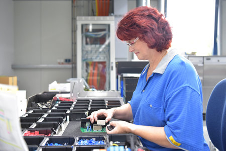 friendly woman working in a microelectronics manufacturing factory - component assembly and...
