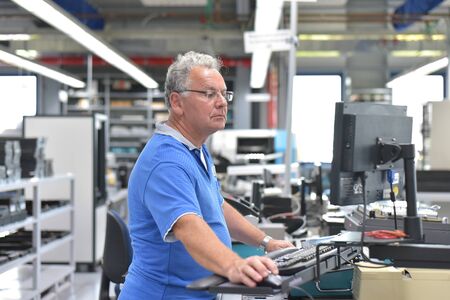 Engineering in microelectronics: senior workers in the production and assembly of electronic high tech components in a modern factoryの写真素材