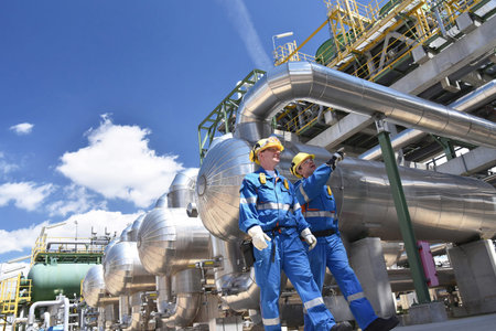 Group of industrial workers in a refinery - oil processing equipment and machineryの写真素材