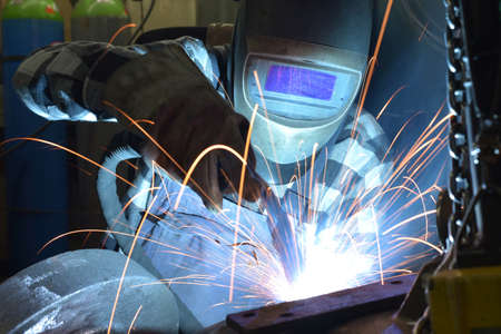 Welder in protective clothing at the workplace in an industrial company in steel constructionの写真素材