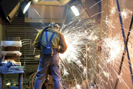 Welder in protective clothing at the workplace in an industrial company in steel constructionの写真素材