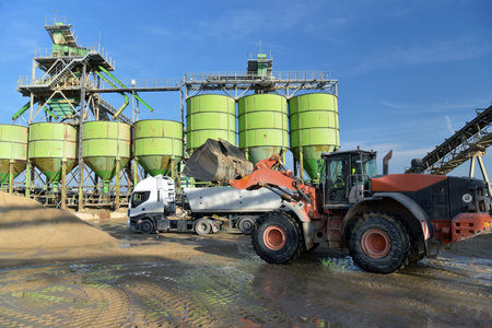 Gravel pit: building and wheel loader loading gravel onto a truck