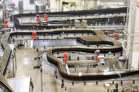 Modern factory in the food industry - beer brewery - conveyor belt with beer bottles and machines for productionの写真素材