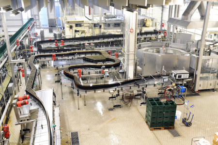 Modern factory in the food industry - beer brewery - conveyor belt with beer bottles and machines for productionの写真素材