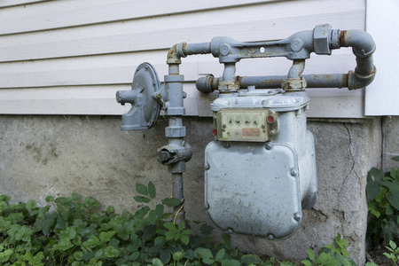 Older residential  gas meter on the outside of a home.の写真素材