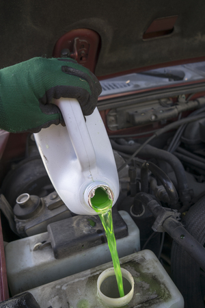 Mechanic filling vehicle with new antifreeze in preperation for winter.の写真素材