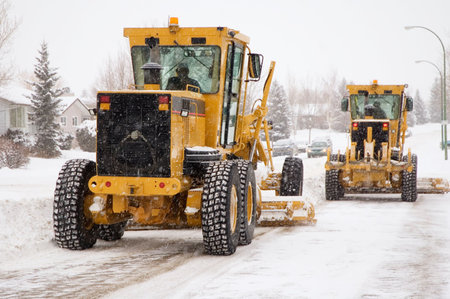 Two city plows clearing snow from the streets.の写真素材