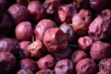 Macro close-up of dried jujube fruits with wrinkled red skin, traditional Asian dried fruit used for food, herbal medicine, and health concepts.の写真素材