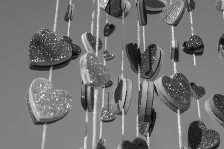 Multiple hearts hanging from a string in black and whiteの写真素材