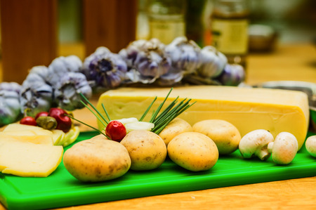 cheese and ingredients for preparing food on a wooden table.の写真素材