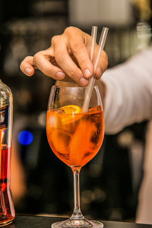 Bartender preparing Aperol Spritz cocktail drink at the barの写真素材