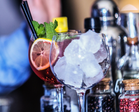 Closeup of barman hand putting on a glass to prepare cocktail.の写真素材