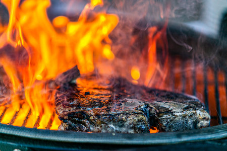 Grilling steaks on flaming grill.Beef steaks on grill.Grilling steak on BBQ