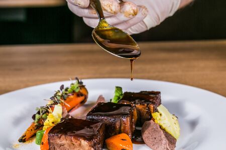 Close up hands of chef preparing food in the kitchen of a restaurant, cooking conceptの写真素材