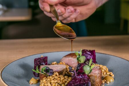 Close up hands of chef preparing food in the kitchen of a restaurant, cooking conceptの写真素材