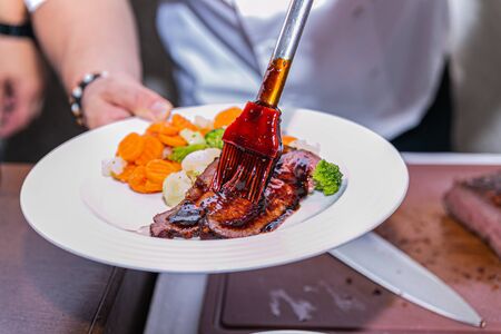 Close up hands of chef preparing food in the kitchen of a restaurant, cooking conceptの写真素材
