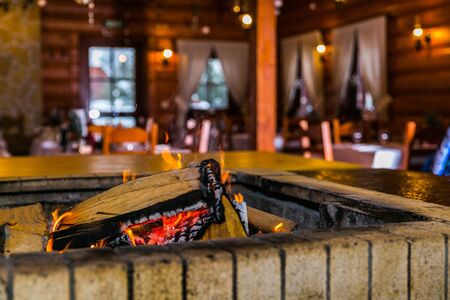 Cosy style restaurant with a stove wood fire burning in fireplace. Hot embers in a bonfire. Closeupの写真素材