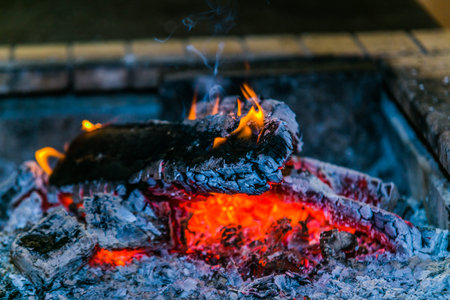 Wood fire with flames, charcoal and embers. Hot embers in a bonfire. Close up