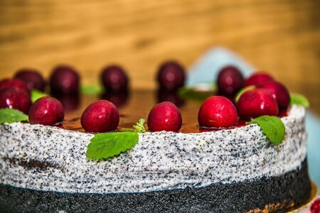 Delicious sweet poppy cake with different fresh cherry. Sweet homemade cake. Closeupの写真素材