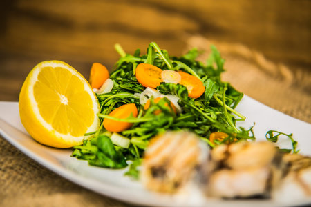 Grilled fish fillet with fresh vegetables served on plate. The food in the restaurant. Food styling...