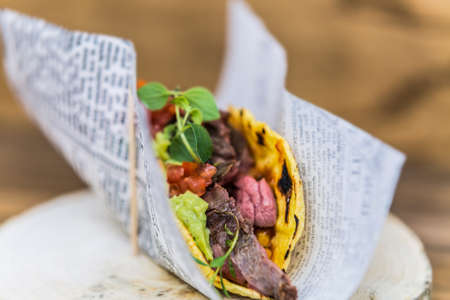 Mexican tacos with meat, salsa and vegetables on a wooden base. The food in the restaurant. Food styling and restaurant meal serving.の写真素材