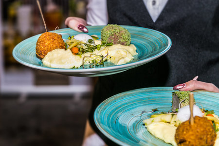 close-up on the hand of a waiter carrying food. The food in the restaurant. Food styling and...