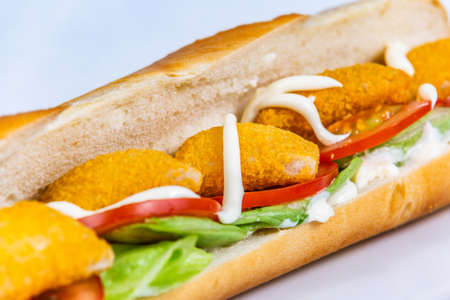 Baguette stuffed with cheese nuggets and vegetables. Food styling for street food. Closeup.の写真素材