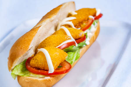 Baguette stuffed with cheese nuggets and vegetables. Food styling for street food. Closeup.の写真素材